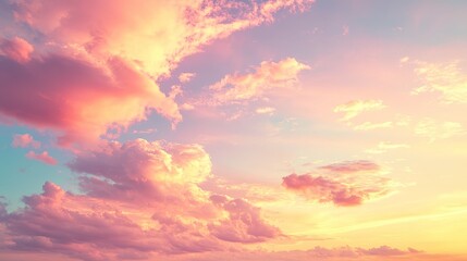 Obraz premium Pastel pink and orange sunset cloudscape. Soft light illuminates fluffy clouds against a light blue sky. Dreamy and peaceful atmosphere. Wide shot