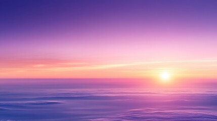 Obraz premium Purple and orange sunset over a wide, snow covered landscape. The sun glows brightly on the horizon, casting a warm light over the scene. A serene