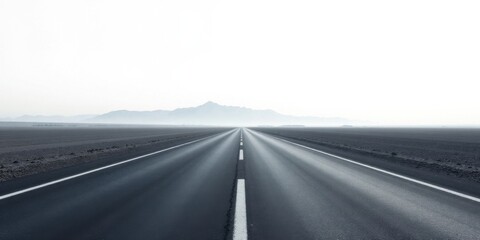 A long, straight highway stretches towards a hazy mountain range on a pale, desolate plain under a bright, clear sky, symbolizing an open road and the journey ahead.