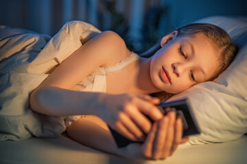 Obraz premium girl with phone in the bed