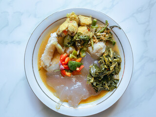 Papeda traditional Maluku food made from sago with side dish yellow fish soup and vegetable.