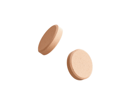Two round, light-colored tablets displayed on a plain background.