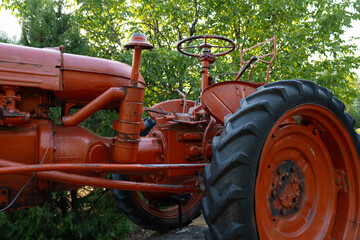 A red tractor in a forest area. Ideal for small land plots where high power is not required, providing efficient and reliable operation.