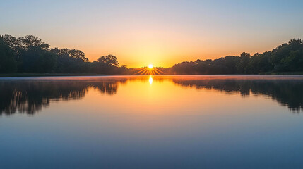 Obraz premium Serene sunrise over a tranquil lake, reflecting vibrant colors, surrounded by lush trees and calm waters
