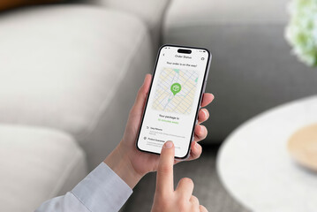 Smartphone screen displays an order tracking app with a map showing a package icon en route to...