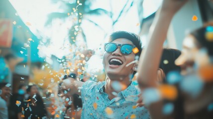 Blurred asian friends having fun throwing confetti at party outdoor - Young trendy people enjoying fest event - Hangout, friendship, trends and youth concept - Defocused photo - obrazy, fototapety, plakaty