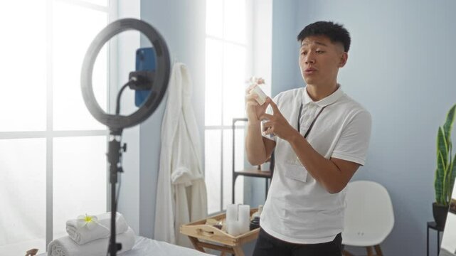 Young man broadcasting from a spa room while reviewing beauty products, surrounded by soothing decor and wellness items