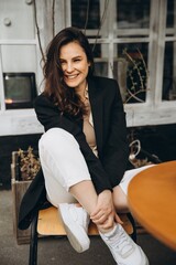 portrait of a young well-groomed woman with a beautiful smile dressed in stylish comfortable casual clothes, autumn or spring time, a walk on the street, selective focus, noise effect