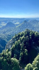 Vertical photo of the view from Mount Trzy Korony overlooking surrounding mountains and trees in Pieniny National Park, Poland, Slovakia. Perfect for travel, hiking, and outdoor activity themes. © Krystsina_Semianiuk