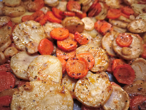 Close up of seasoned roasted potatoes and carrots, showcasing a warm and savory dish. Captured on sobi street in prague, czechia easy dinner