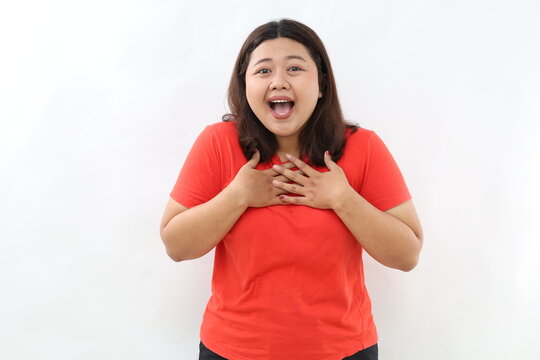 Image of surprised and grateful asian woman receive gift, holding hands on chest with flattered smile, saying thank you, being praised, standing over white background.