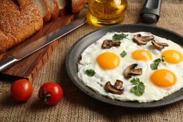 Tasty fried eggs with mushrooms and parsley served on table, closeup