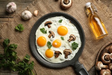 Tasty fried eggs with mushrooms and parsley served on wooden table, flat lay