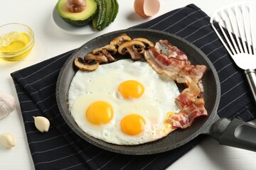 Tasty fried eggs with bacon and mushrooms served on white wooden table, closeup
