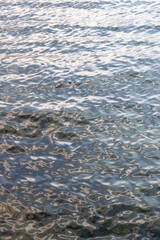 Slowly moving littles waves on water with reflections