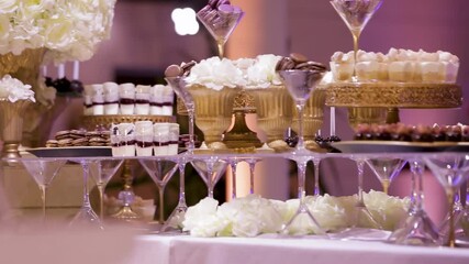 Elegant dessert display at a lavish celebration with floral arrangements