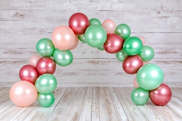 Obraz premium Colorful Balloon Arch Decorated with Pastel Pink, Green, and Red Balloons for Celebrations and Events