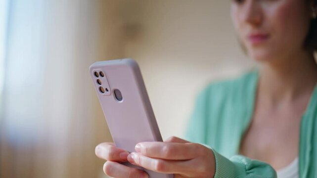 Lady hands texting cellphone in modern living room closeup. Smiling woman