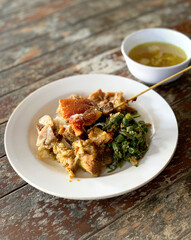 Balinese tradidional food, Chicken Betutu with Matah Chili sauce. Chicken Betutu is a famous chicken dish from Bali with skewers and seasoned drumstick, with peas and famous matah chili sauce..