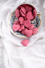 Pink heart-shaped candies in a cup. Valentine's Day background