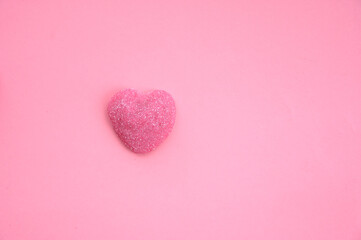 Pink heart-shaped candy on a pink background. Space for text. Valentine's Day Background