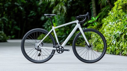 White gravel bike on paved path, lush green background.  Outdoor adventure cycling image for marketing