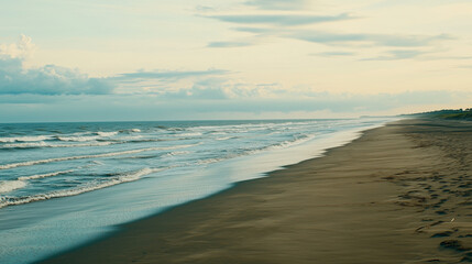 Obraz premium A stunning sandy beach with soft blue waves rolling in, under a pastel-colored sky during sunset, with ample copy space. Warm, glowing lighting. Serene and dreamlike 