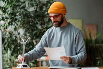 Engineer analyzing wind turbine model and energy consumption report