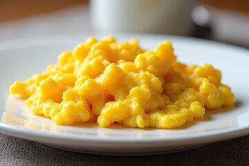 plate of creamy scrambled eggs served on white dish, showcasing soft and fluffy texture
