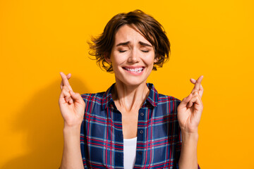 Photo of nervous worried woman with short hairdo dressed plaid shirt hold fingers folded make wish...