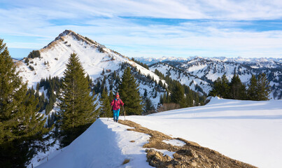 active senior woman  in winter on the Nagelfluh mountain chain near Oberstaufen, Bavaria, Germany