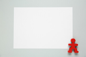 Blank paper and human figure on light grey background, top view. Space for text