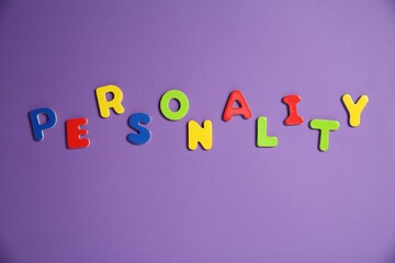 Word Personality made of colorful letters on purple background, top view