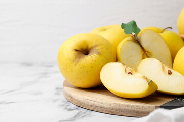 Ripe yellow apples on white marble table, closeup