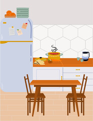 The interior of a modern, cozy kitchen with a refrigerator, countertop and dining table.