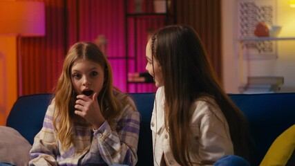 Teen girl shares an exciting secret with her friend, and they hug in celebration