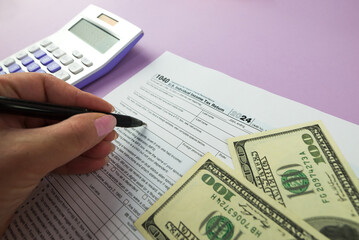 1040 tax form 2024 . Tax return forms 1040 with office supplies and dollar bills. Time to pay taxes.