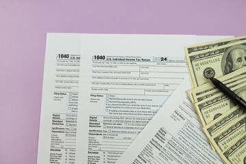 Naklejka premium 1040 tax form 2024 . Tax return forms 1040 with office supplies and dollar bills. Time to pay taxes.