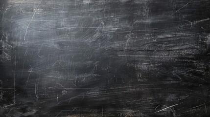Obraz premium Dark black chalkboard for school display with erased chalk traces providing space for text or graphics. Education-themed grunge background.