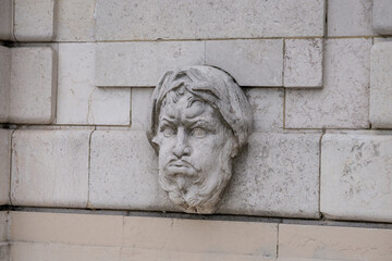 Sculpted stone face embedded in the wall reveals historical craftsmanship