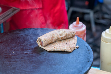 Flavorful street food creation with fresh ingredients at a bustling market
