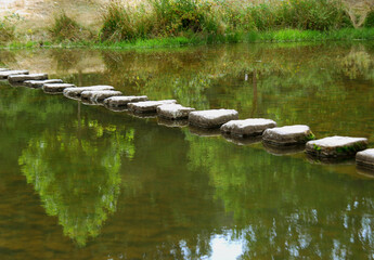 Stone path over quiet river landscape.
