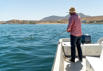 Fototapeta premium Man Fishing from a Boat on the Sea