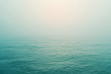 Obraz premium Serene misty ocean landscape at dawn, with calm waters reflecting soft light and tranquility