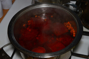 Red borscht, cooking beetroot soup in a pot.