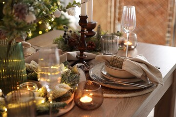 Christmas place setting with festive decor on wooden table in room