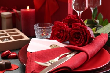 Romantic place setting with red roses on grey table, closeup. Valentine's day celebration