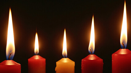 The Colorful Candles with Their Flickering Flames Shine Brightly Against a Dark Background