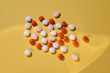 Colorful pills on a yellow background.