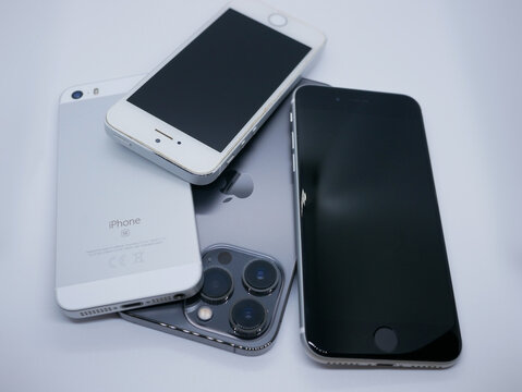 Vienna, Austria - 24 January 2025: Different models of Apple iPhone. iPhone 13 Pro, SE and 5c on white background